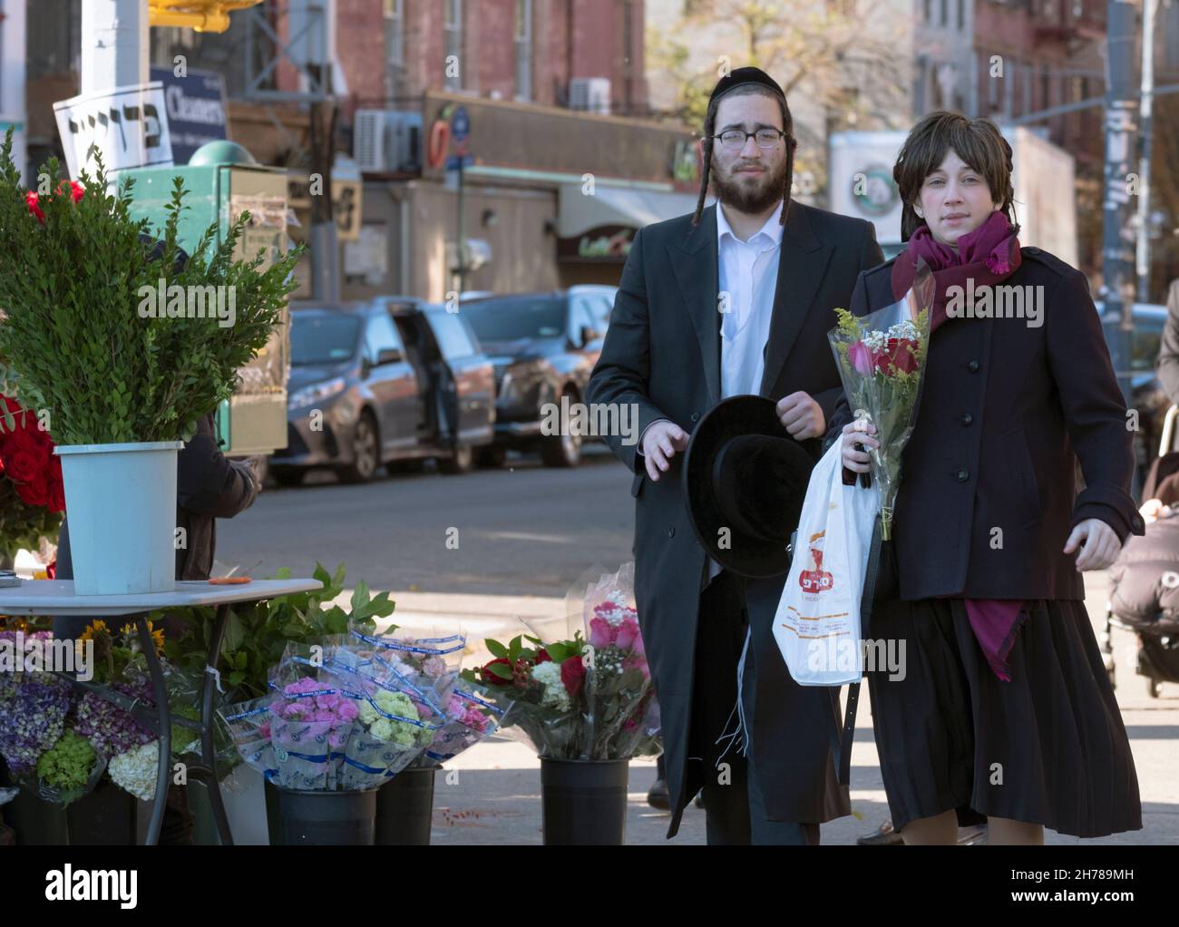 Zur Vorbereitung auf den Sabbat kauft ein orthodoxes jüdisches Paar Blumen. Auf der Lee Avenue in Williamsburg, Brooklyn, New York City. Stockfoto