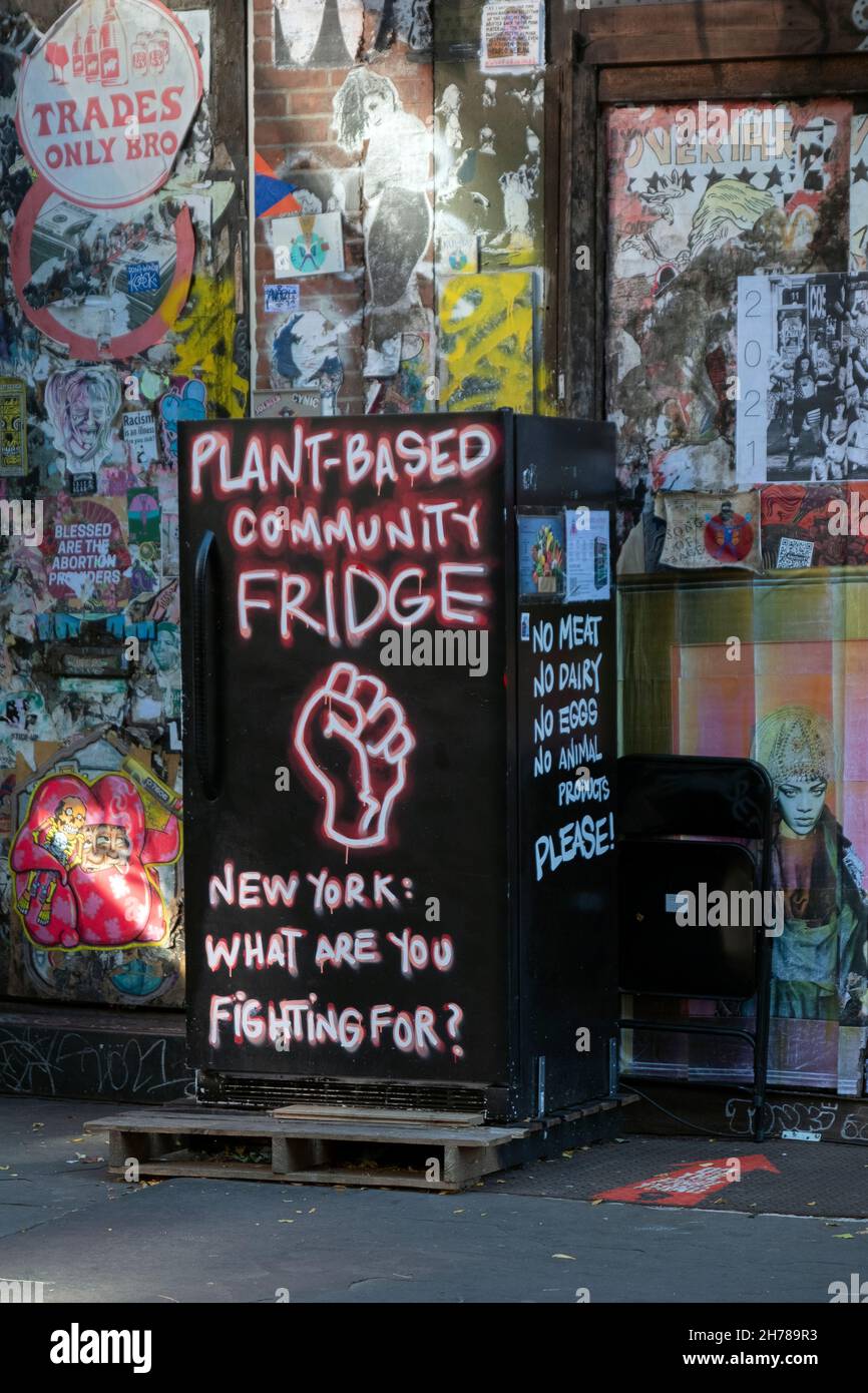 URBANE LANDSCHAFT Ein pflanzlicher Gemeinschaftskühlschrank vor Graffiti-Aufklebern und -Etiketten in der Bleecker Street in Downtown manhattan, New York City. Stockfoto