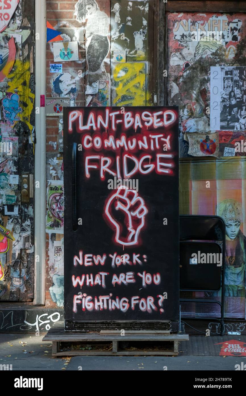 URBANE LANDSCHAFT Ein pflanzlicher Gemeinschaftskühlschrank vor Graffiti-Aufklebern und -Etiketten in der Bleecker Street in Downtown manhattan, New York City. Stockfoto