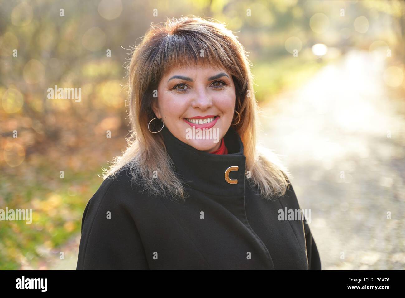 Porträt einer glücklich lächelnden erwachsenen Frau im Freien. Nette Person mittleren Alters Stockfoto
