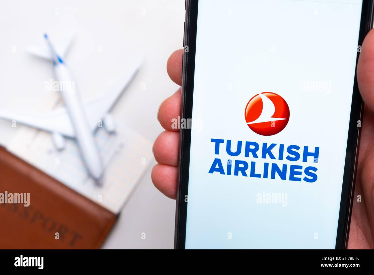 Turkish Airline Anwendung auf dem Bildschirm des Mobiltelefons in mans Hand. Pass, Boarding Bass sind neben einem weißen Flugzeug auf dem Hintergrund. November 2021, San Francisco, USA Stockfoto