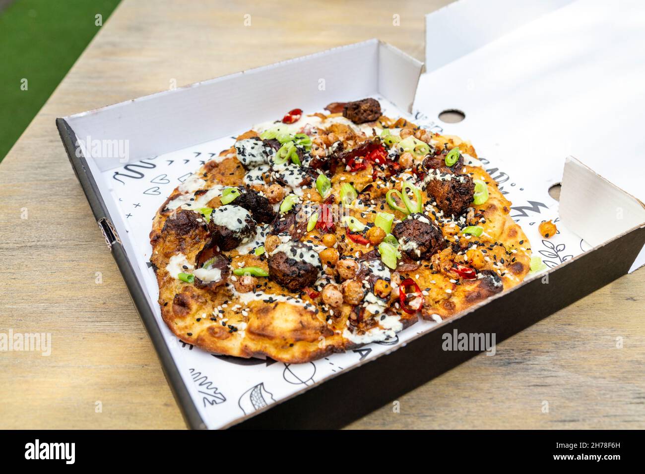 Geräuchertes Fladenbrot mit baba ganoush, Falafel, Kichererbsen und Sesam aus Bad Vegan auf dem Buck Street Market, Camden, London, Großbritannien Stockfoto