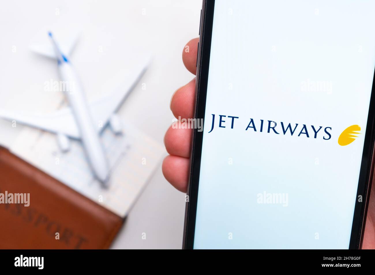 Jet Airways Anwendung auf dem Bildschirm des Mobiltelefons in mans Hand. Pass, Boarding Bass sind neben einem weißen Flugzeug auf dem Hintergrund. November 2021, San Francisco, USA Stockfoto