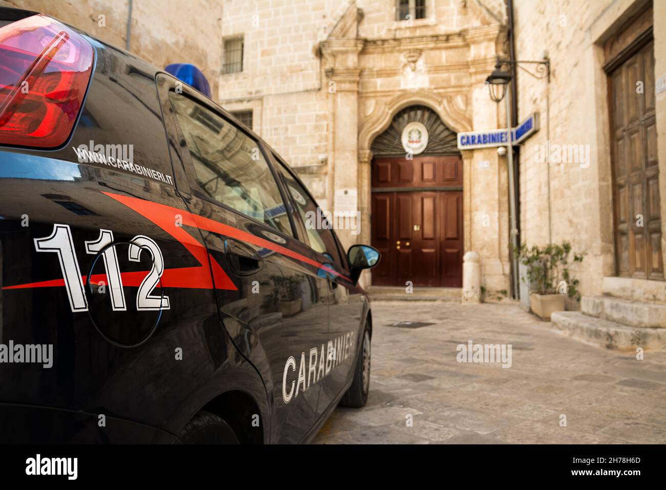 Carabinieri Auto mit der Notrufnummer 112 im Vordergrund und im Hintergrund die Polizeistation von Monopoli (Apulien-Italien) Stockfoto