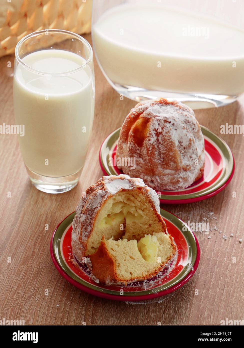 Süßer Hefe-Cupcake gefüllt mit Vanillecreme und frischer veganer Milch. Leckeres Frühstück. Hausgemachtes Gebäck. Stockfoto