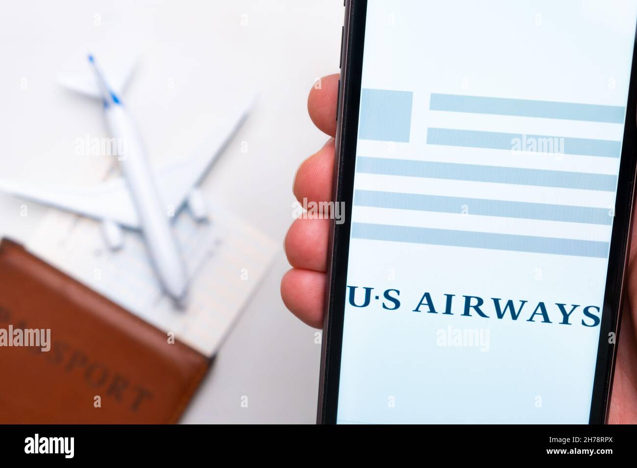 US Airways-Anwendung auf dem Bildschirm des Mobiltelefons in mans Hand. Pass, Boarding Bass sind neben einem weißen Flugzeug auf dem Hintergrund. November 2021, San Francisco, USA Stockfoto