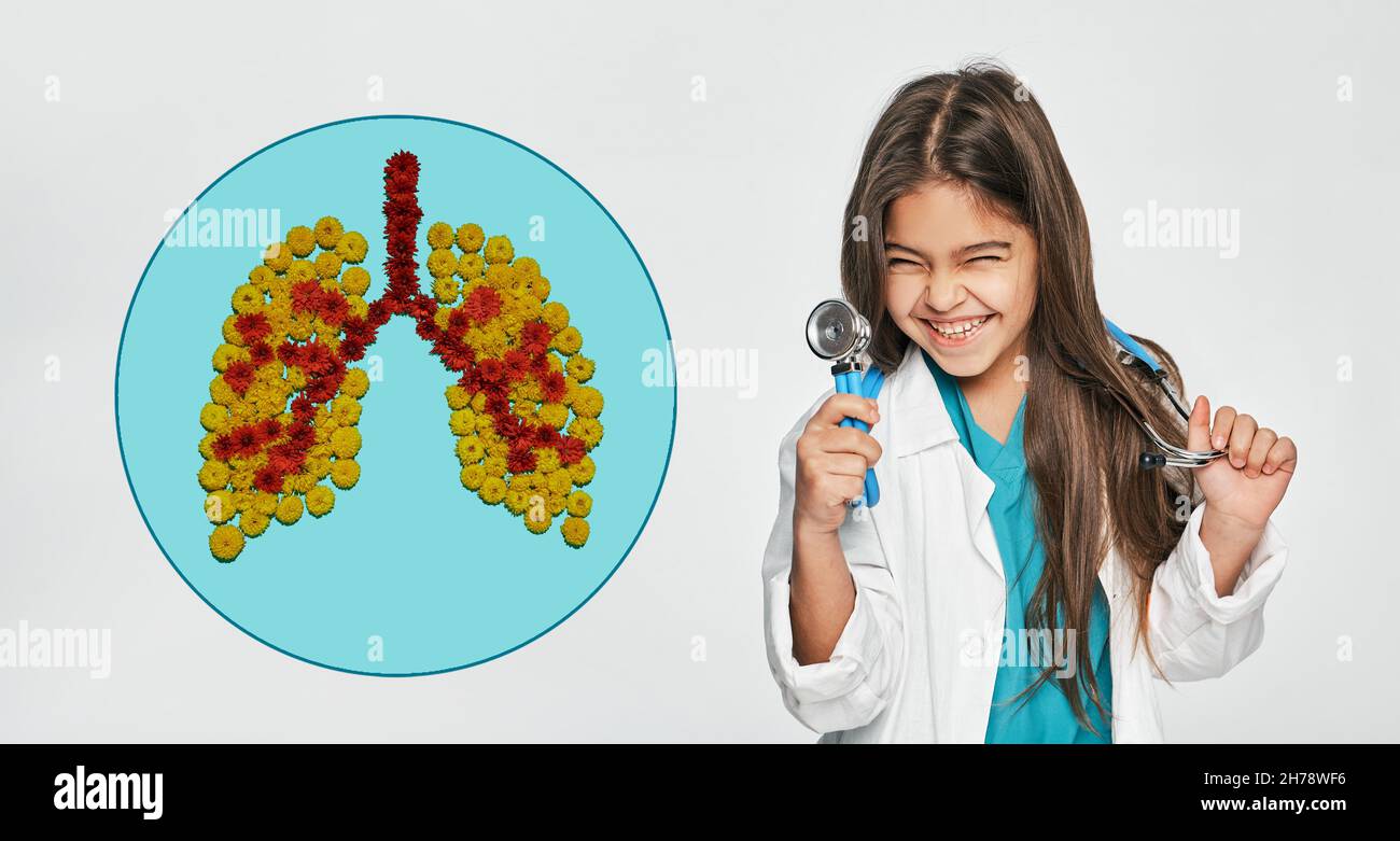 Lungengesundheit von Kindern. Weibliches Kind mit gemischter Rasse in Ärzteuniform mit Stethoskop auf weißem Hintergrund in der Nähe eines Symbols gesunder Lungen aus Blumen Stockfoto