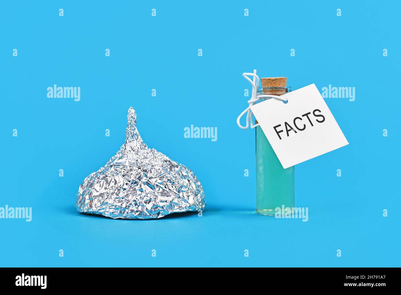 Konzept für die Bekämpfung von Verschwörungstheorien mit Fakten mit einem Kinfoil-Hut und einer Kurflasche mit dem Wort „Fakten“ Stockfoto
