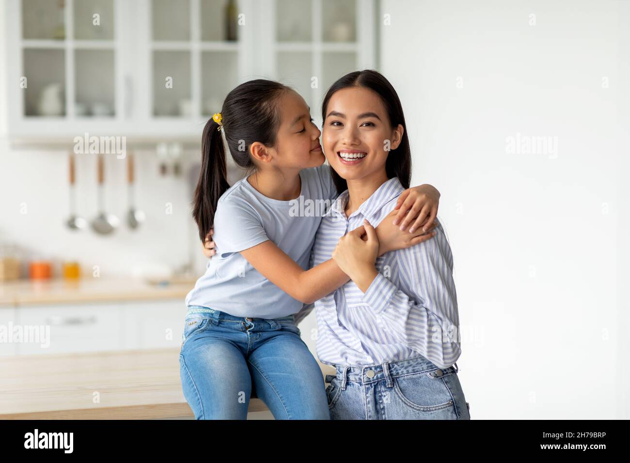 Glücklich asiatische Mutter und Tochter umarmt, schöne junge koreanische Frau Mutter und teen Mädchen kuscheln in der Küche Stockfoto