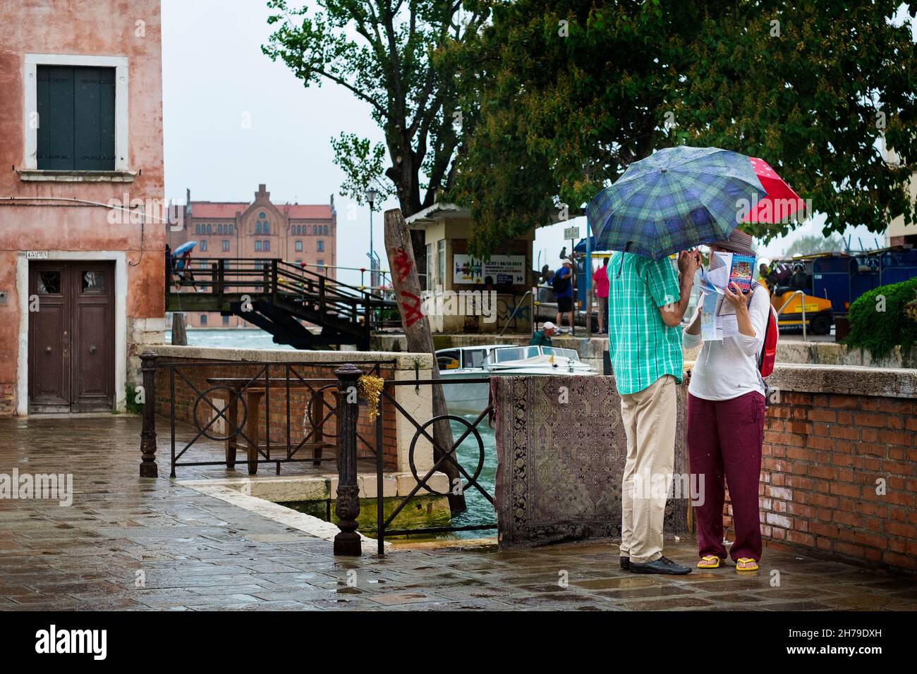 Touristen konsultieren ihre Karte im Regen, Dosoduro, Venedig, Italien. Stockfoto