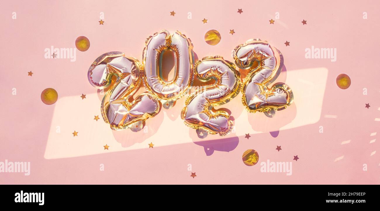 Banner mit der Nummer 2022 der glänzenden rosa Ballons, ein Symbol des neuen Jahres. Abstrakter festlicher Hintergrund. Flaches Lay.Symbol frohes neues Jahr 2022. Pastell Stockfoto