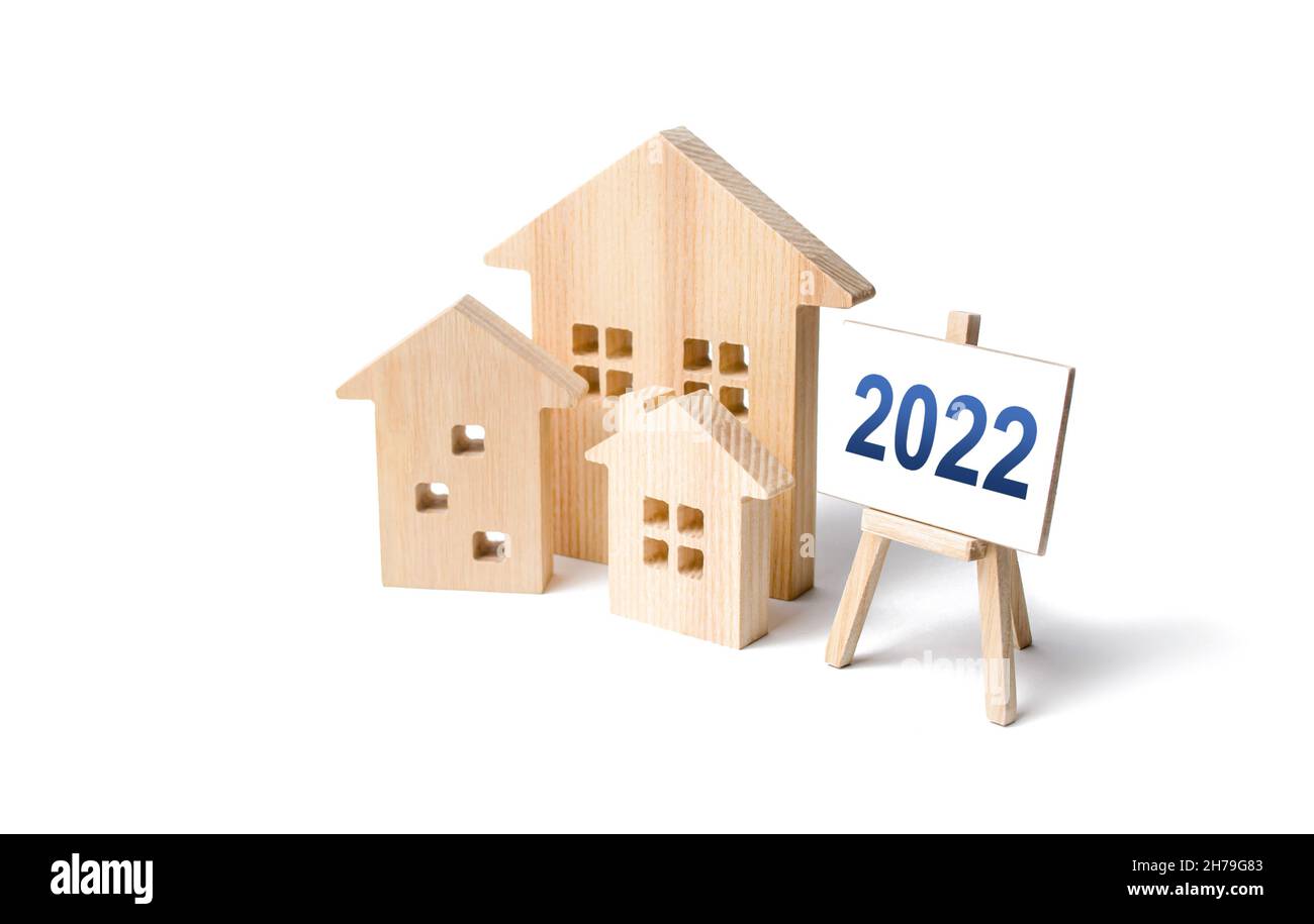 Wohngebäude und Staffelei 2022. Konzept des Immobilienmarktes im neuen Jahr. Prognosen, Trends und Tendenzen des Immobilienmarktes. Investitionspläne. Stockfoto