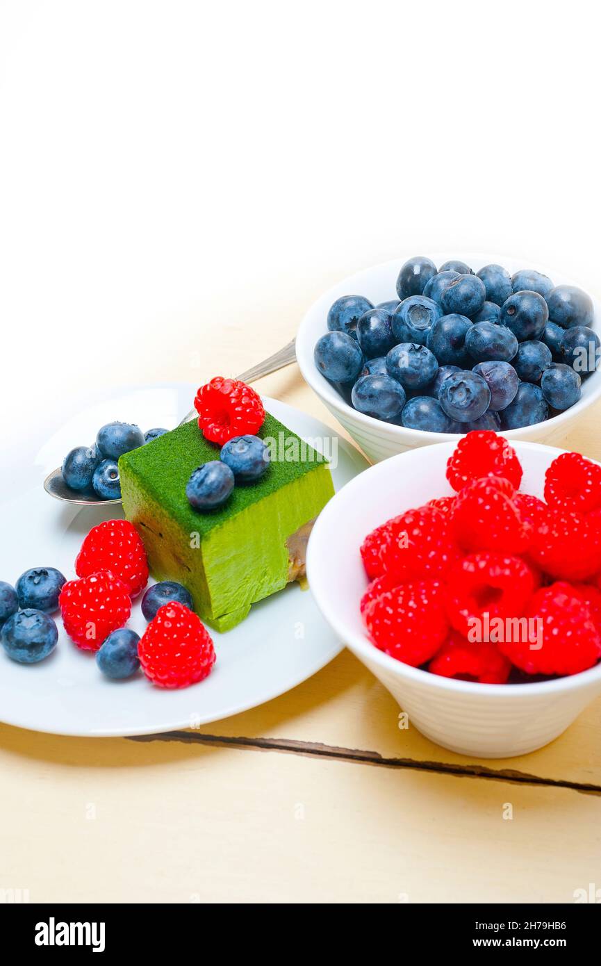 Grüner Tee Matcha Mousse Torte mit Himbeeren und Heidelbeeren an der Spitze Stockfoto