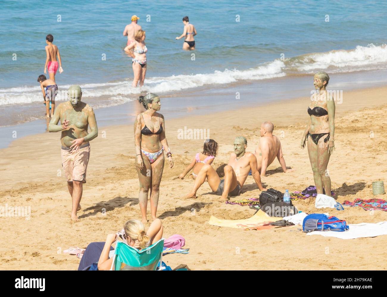 Gran Canaria, Kanarische Inseln, Spanien. 21st. November 2021. Touristen, viele aus Großbritannien, sonnen sich am Stadtstrand von Las Palmas auf Gran Canaria in herrlicher Sonne; ein beliebtes Wintersonnenziel für viele britische Urlauber. IM BILD: Touristen genießen eine Ganzkörper-Schlammpackung am Stadtstrand in Las Palmas. Quelle: Alan Dawson/Alamy Live News. Stockfoto