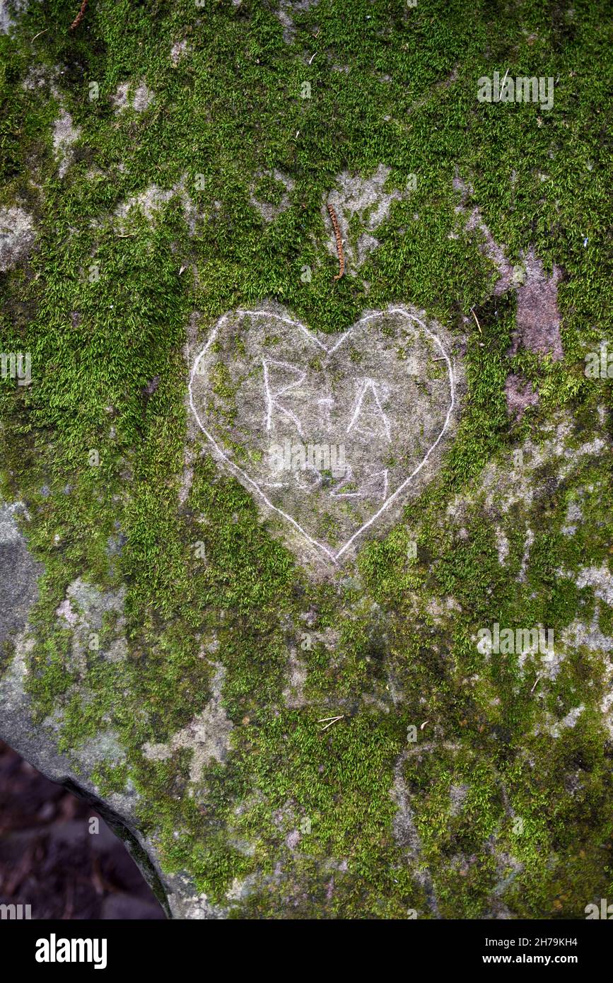 Grünes Herz in Moss oder auf Mossy Boulder oder Moss-Covered Rock geschnitzt Stockfoto