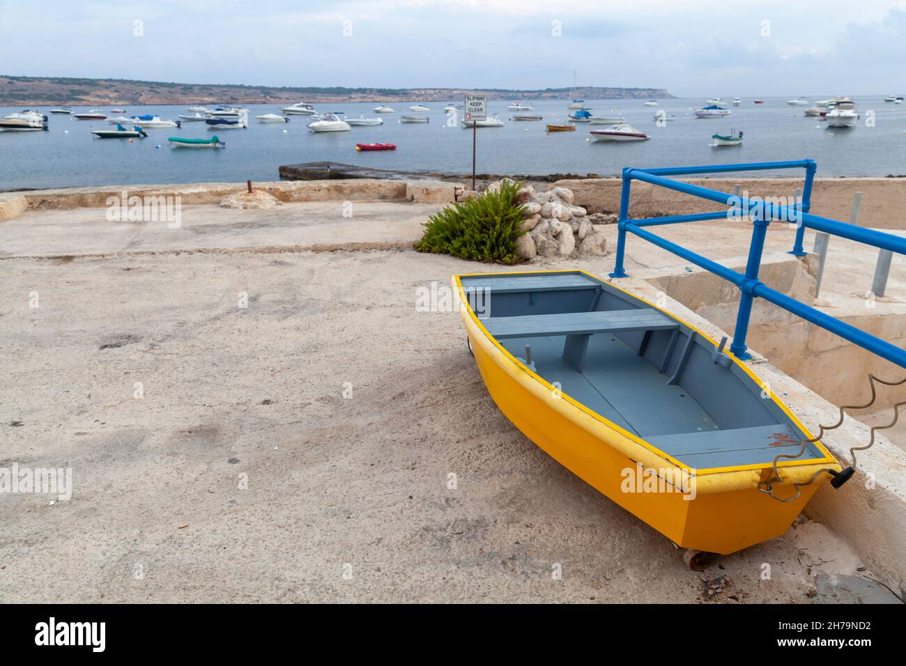 Kleines gelbes Boot liegt auf dem Boden im Hafen von Mellieha, Malta Stockfoto