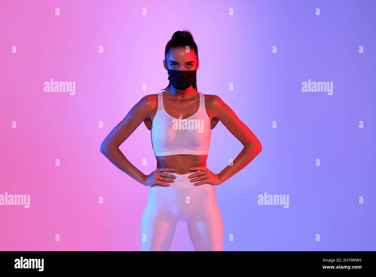 Fitness Frau Trägt Schutzmaske Posiert Auf Neon-Hintergrund Stockfoto