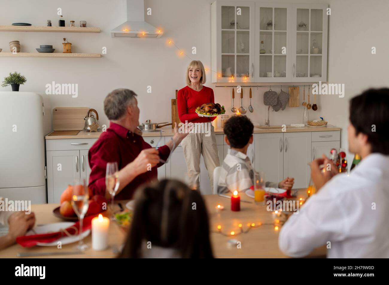 Glückliche ältere Frau, die Urlaub türkei für große Großfamilie, Thanksgiving oder Weihnachten zu Hause zu feiern Stockfoto