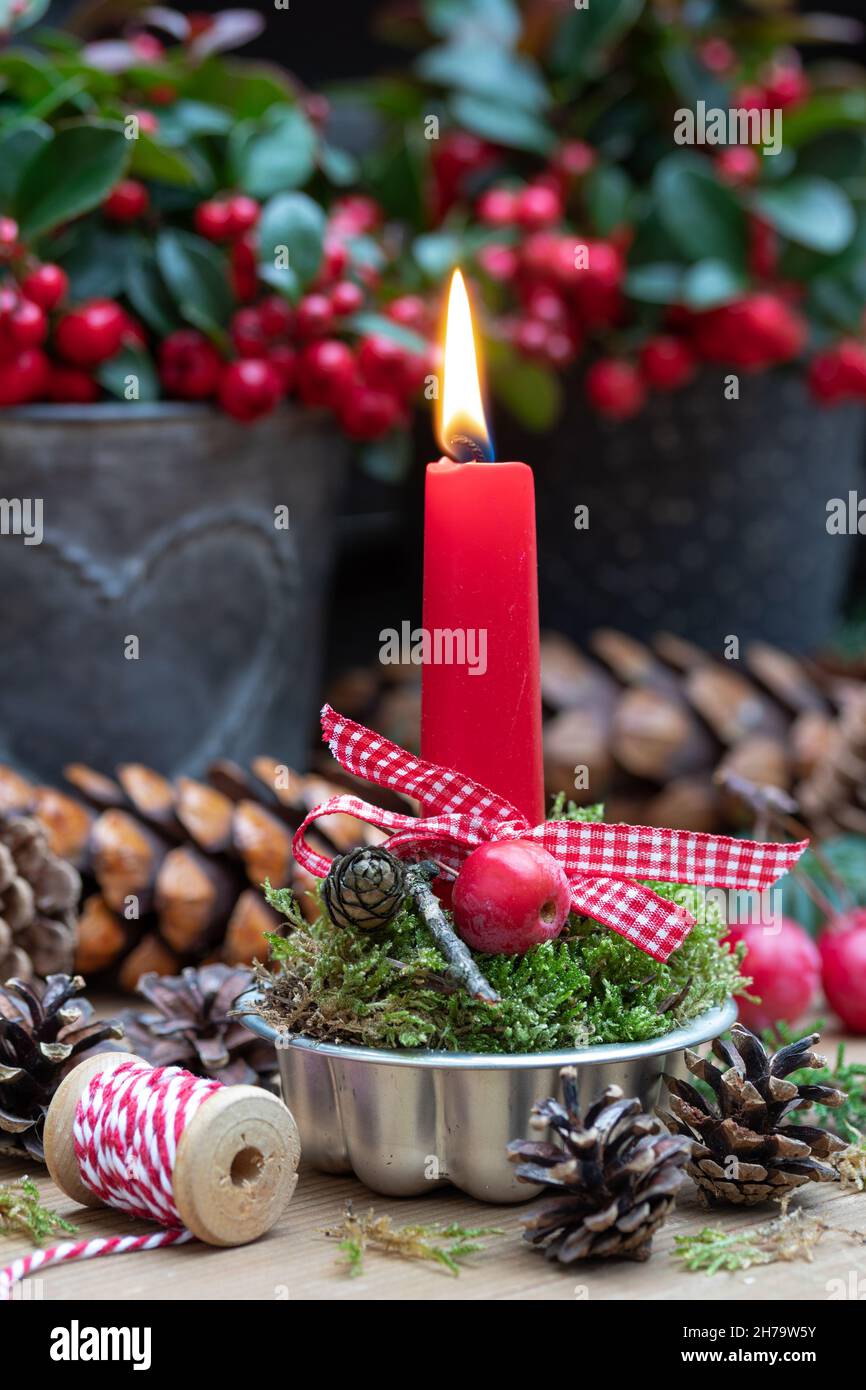 weihnachtsdekoration mit roter Kerze in Vintage-Backform Stockfoto