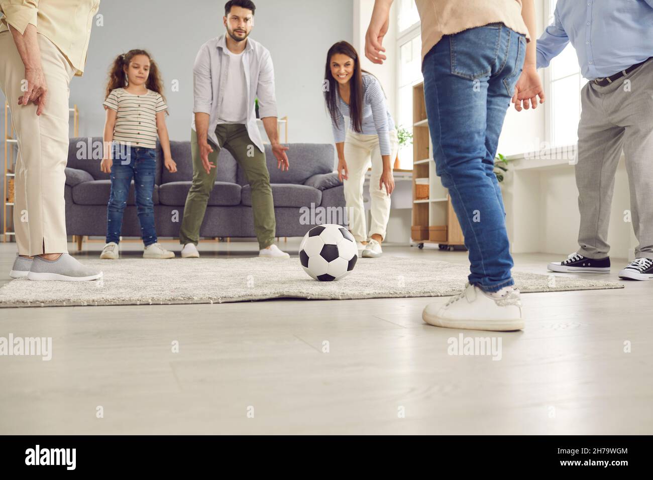 Glückliche Mutter, Vater, Großeltern und Kinder, die mit Fußball spielen und Spaß zu Hause haben Stockfoto