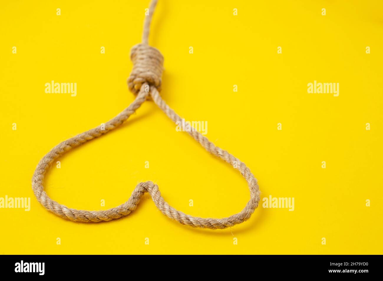 Jute Seil bildet ein Herz auf gelbem Hintergrund, Seitenansicht selektiver Fokus Stockfoto