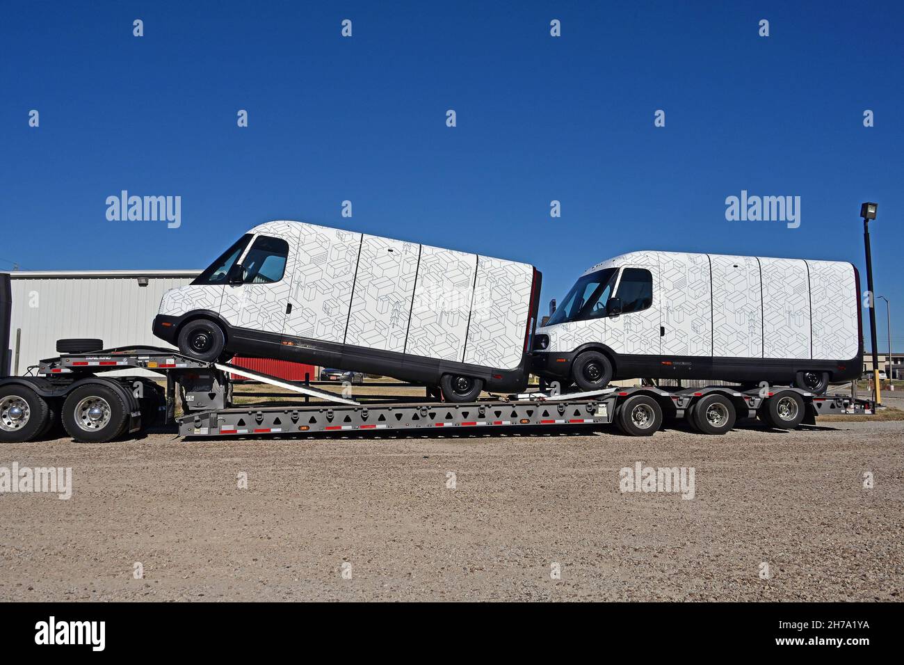 Zwei brandneue Modelle EDV 500 Rivian Electric Delivery Vans (EDV) sind  Teil des Flottenauftrags für Amazon auf der Rückseite eines im Knights Inn  Motel geparkten Transport-Tieflader, während sie vom Produktionswerk im  normalen