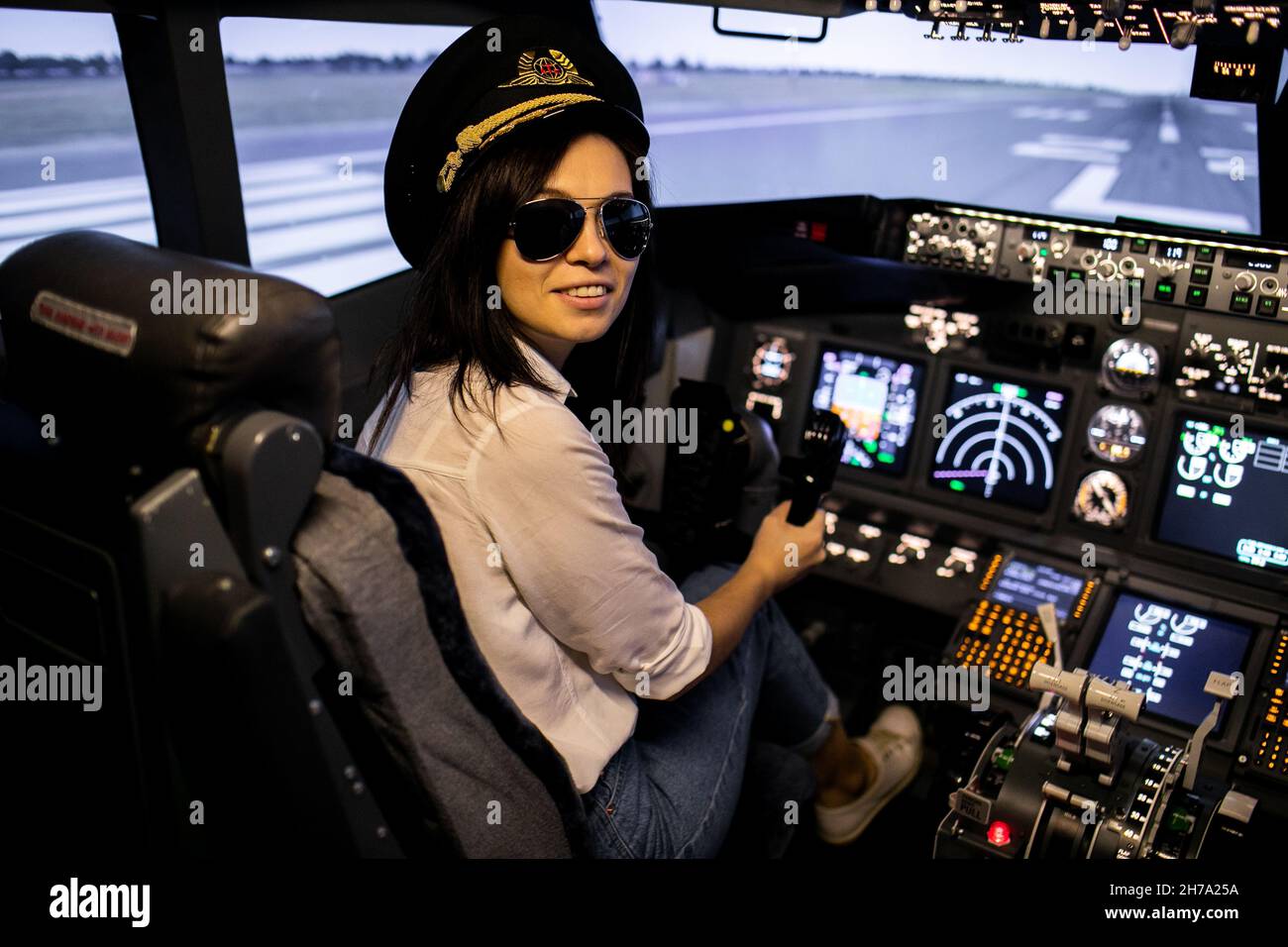 Weibliche Pilotin im Flugzeug-Cockpit. Pilot trägt Sonnenbrille und Hut Stockfoto