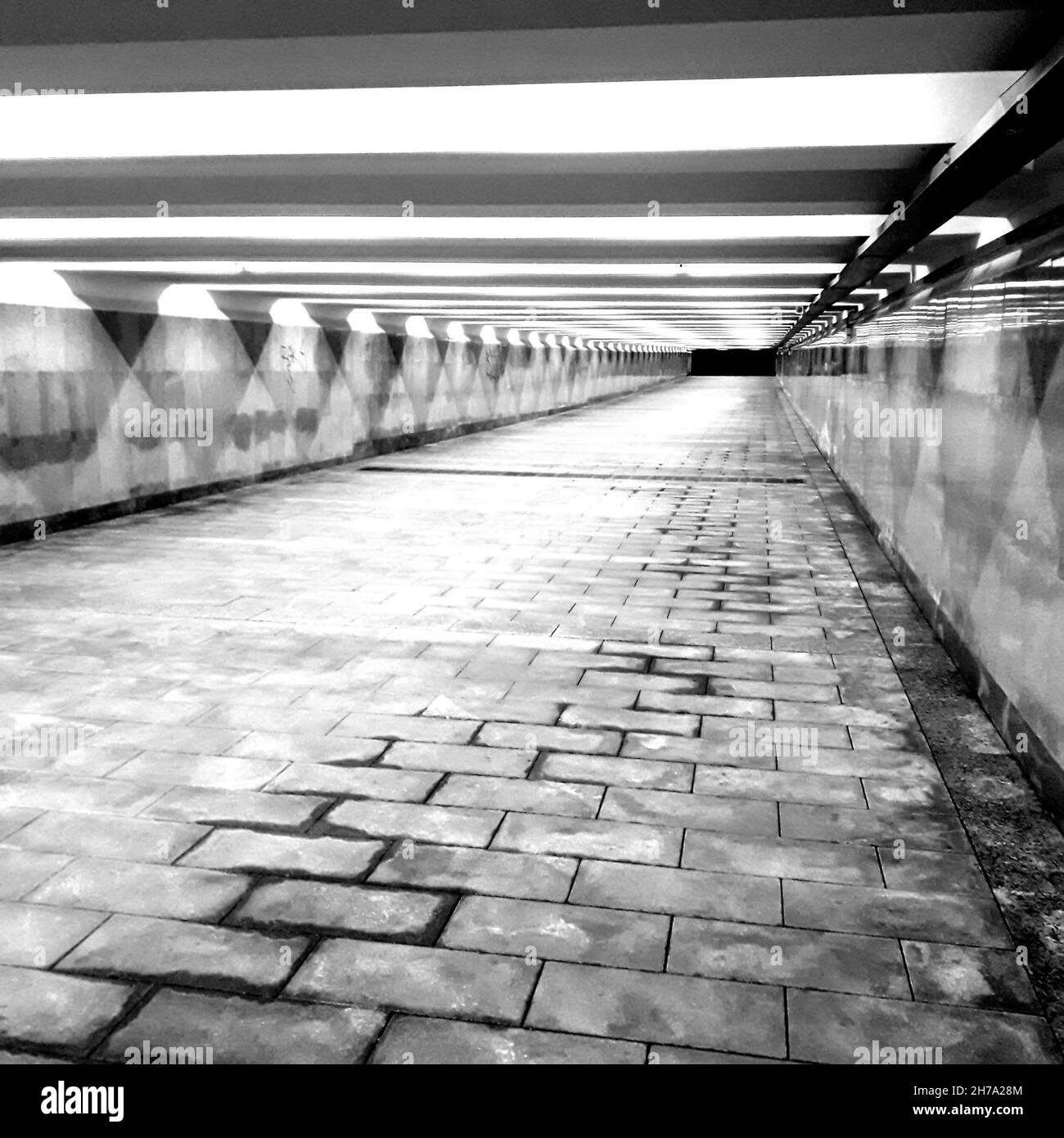 Schöne Kunstfoto unterirdische Fußgängerüberfahrt in der Stadt durch künstliches Licht beleuchtet. Stockfoto