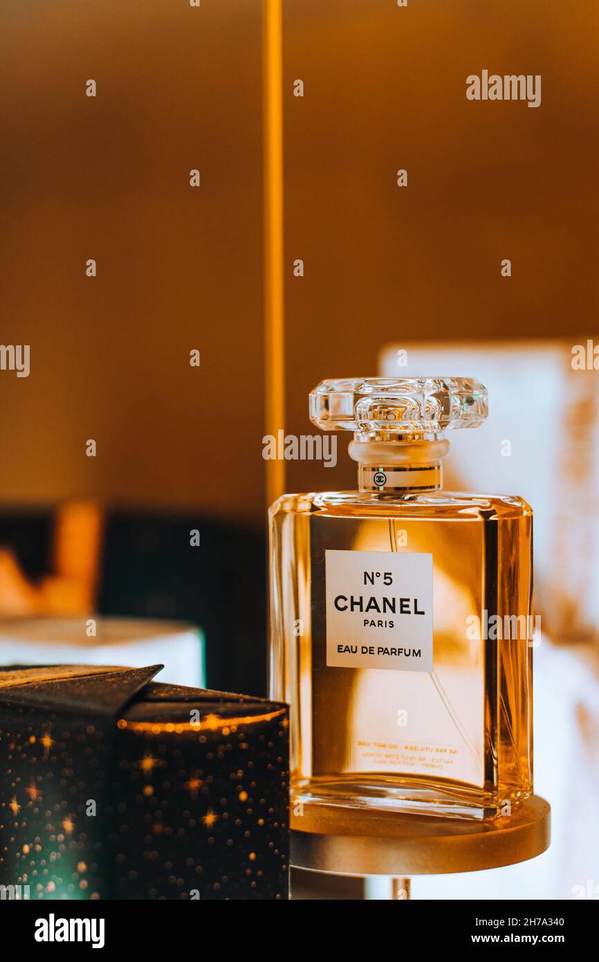 Präsentation der Glasflasche Chanel No. 5 Parfüm der französischen Luxusmarke Chanel vor dem goldenen Hintergrund. Berühmter weiblicher Duft. Stockfoto