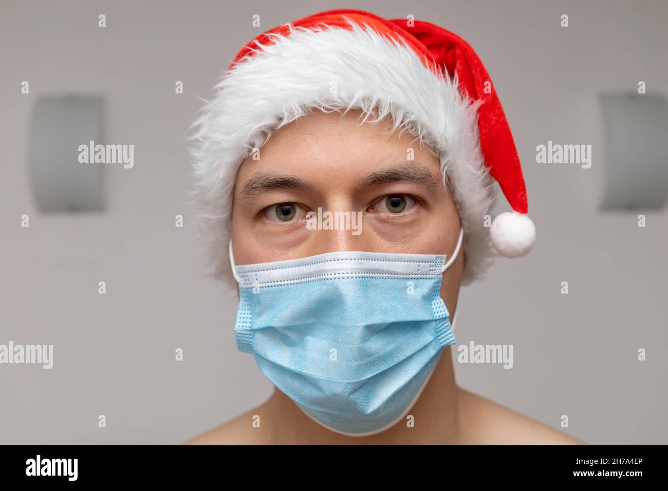 Portrait Mann in Weihnachtsmann Hut und Gesichtsmaske Stockfoto