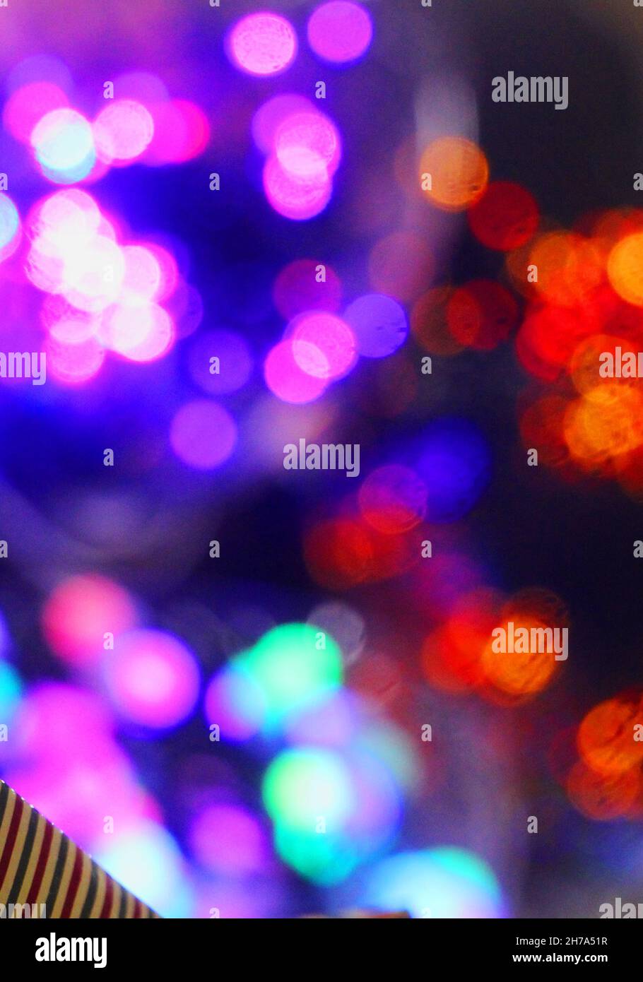 Frohe Weihnachtskarte. Bunte Lichter Bokeh auf lila Hintergrund. Stockfoto