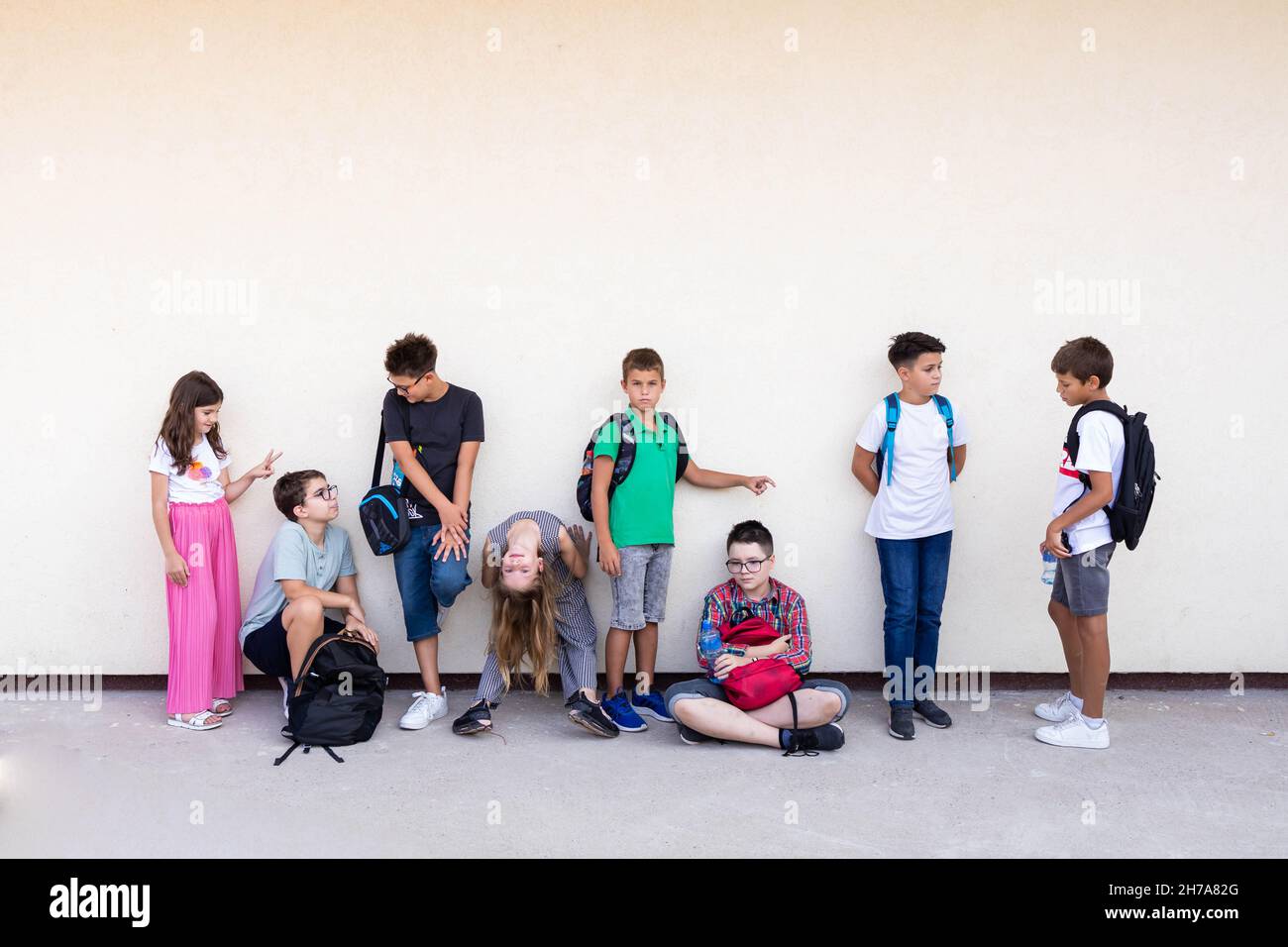 Gruppe von Grundschulkindern, die vor dem Unterricht Spaß haben. Zurück zur Schule Stockfoto