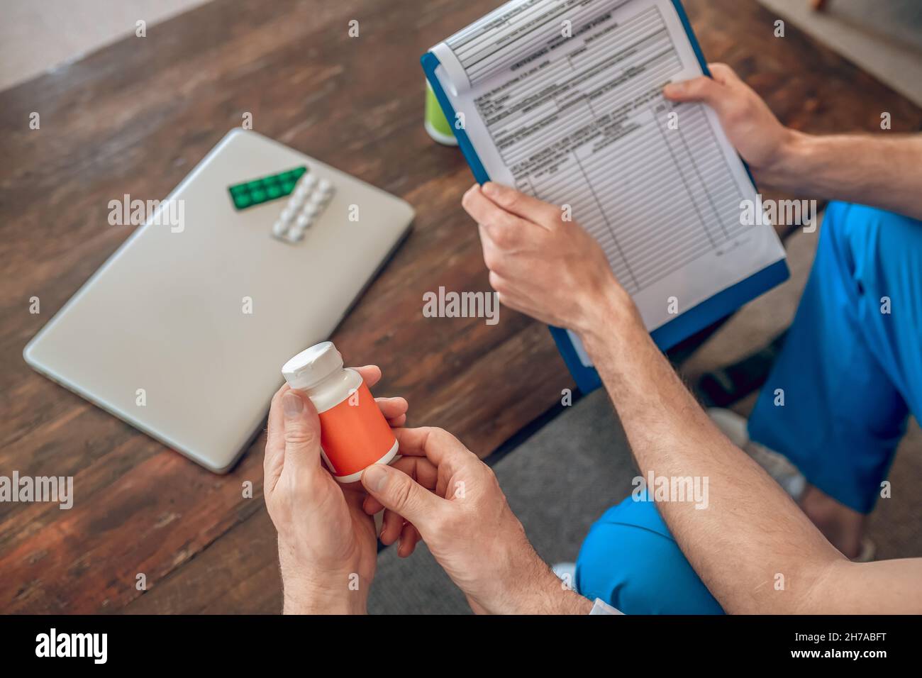 Patient und Arzt wählen Nahrungsergänzungsmittel am Tisch aus Stockfoto