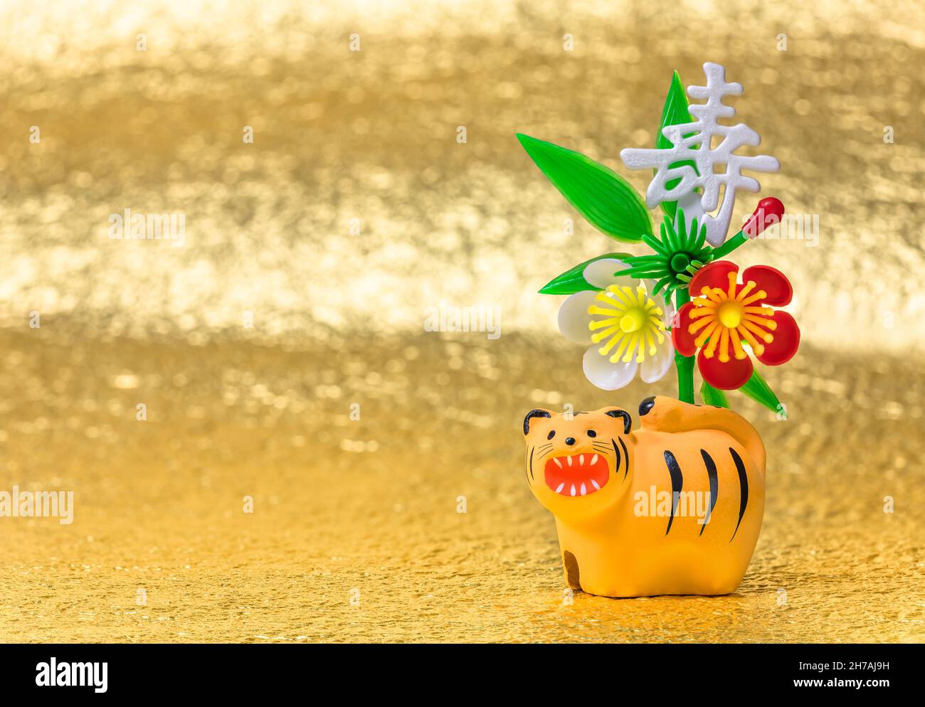Japanische Neujahrskarte mit einer zodiakalen Tierfigur des Tigers für 2022 vor einem aus Kunststoff gefertigten Ideogramm Kotobuki oder Best Wish Stockfoto