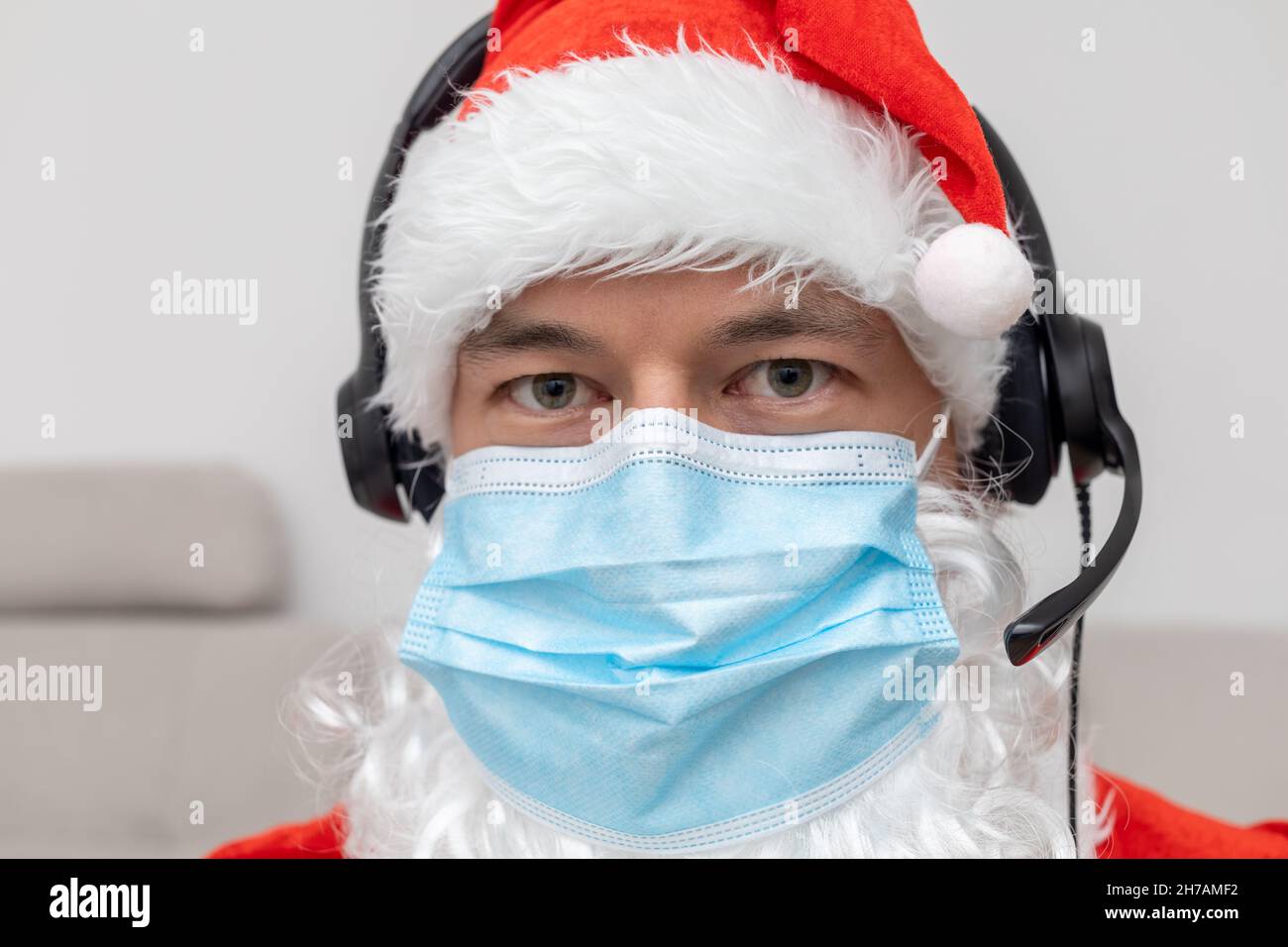 Mann, der als Weihnachtsmann in Kopfhörern gekleidet war Stockfoto