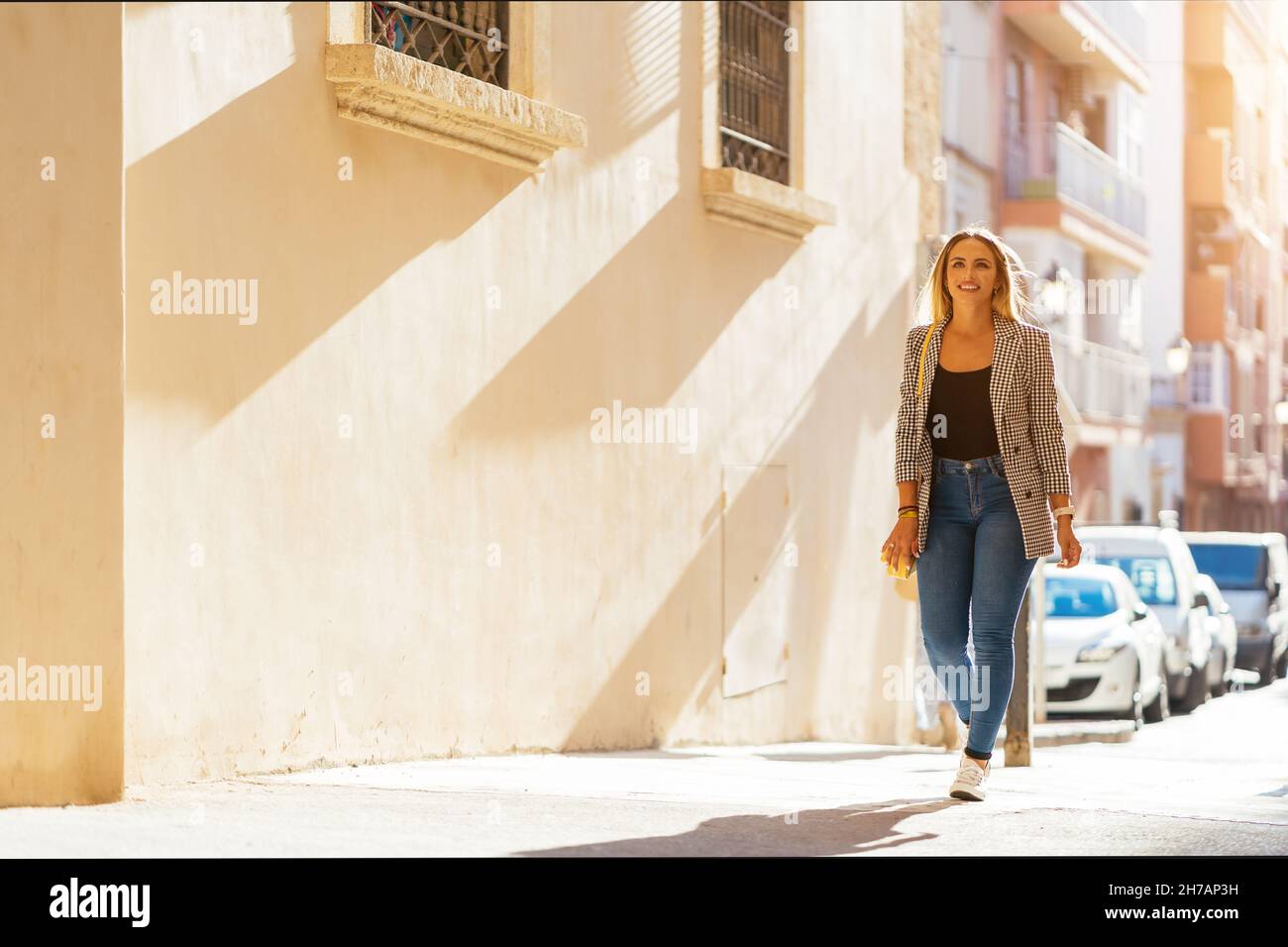 Trendige Frau, die auf der Straße läuft Stockfoto