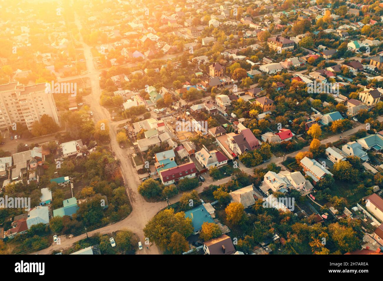 Luftaufnahme bei Sonnenuntergang von Wohngebiet mit vielen Häusern. Vorstadtgebäude in der Nähe der Nachbarschaft. Stockfoto