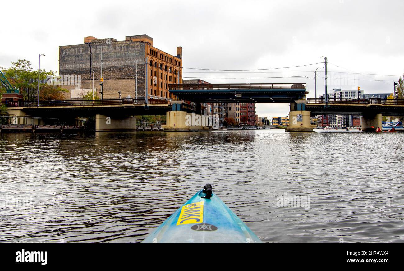 Kajakfahren auf dem Milwaukee River. Die Stadt hat 179 Brücken. Einige steigen auf, um an Booten vorbei zu fahren, indem sie einen Mittelteil, der gerade nach oben steigt, abschreckt. Stockfoto