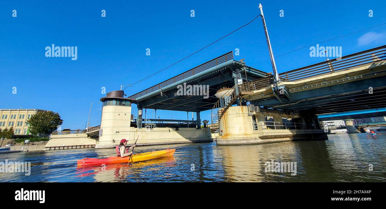 Kajakfahren auf dem Milwaukee River. Die Stadt hat 179 Brücken. Einige r ise gerade nach oben wie eine Tischplatte für vorbeifahrende Boote. Stockfoto