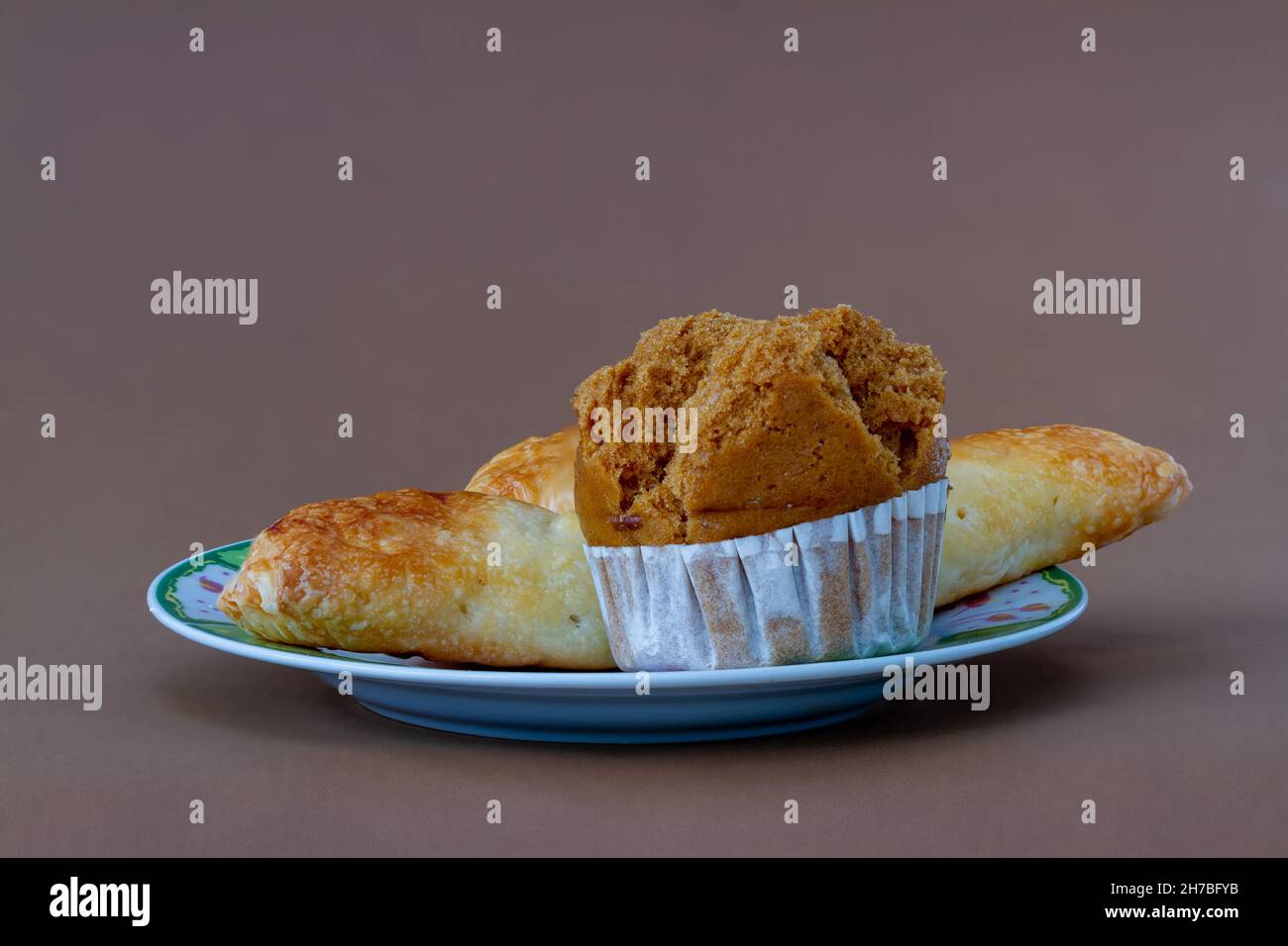 Ein Croissant und Biskuitkuchen auf einem kleinen Teller für Frühstück und Kaffee, Platz zum Kopieren Stockfoto