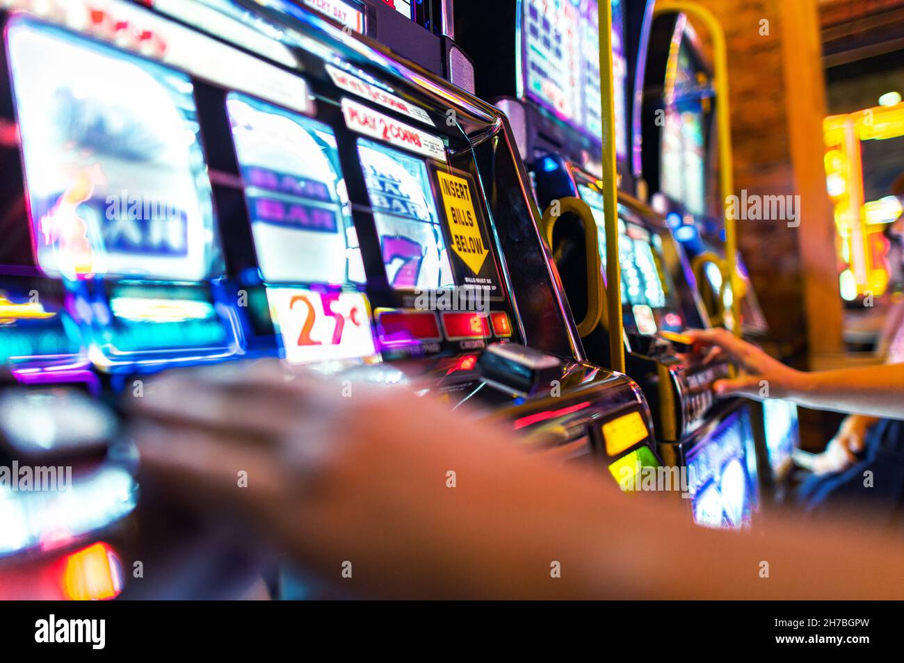 American Casino Spielautomaten Spieler. Linie von einhändigen Bandits Maschinen. Unterhaltungsbranche. Stockfoto