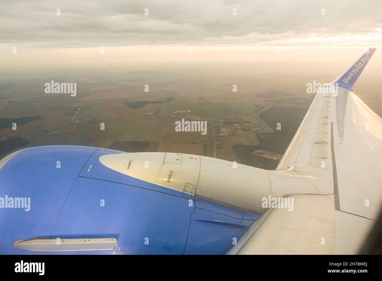 Jet-Triebwerk und Flügel eines Boeing 737-800-Flugzeugs von Belavia, das am Sonnenuntergang über Weißrussland fliegt Stockfoto