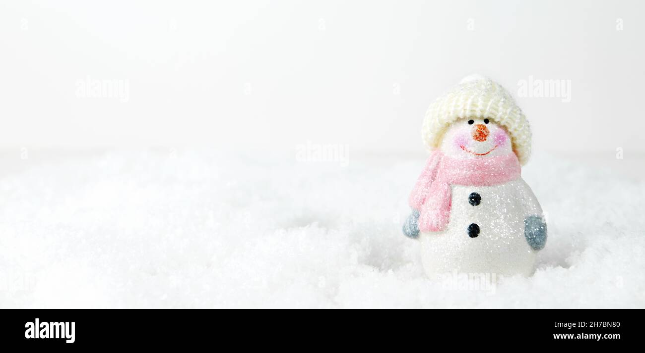 Weihnachten Hintergrund. Glücklicher Schneemann steht in der winterverschneiten Weihnachtslandschaft. Frohe weihnachten und eine Grußkarte zum guten neuen Jahr. Lustige Schneemann in einem Stockfoto