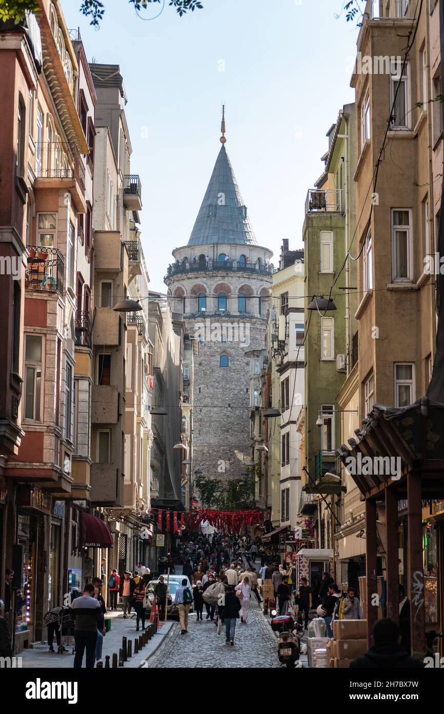 Touristen und Einheimische in der Büyük Hendek Straße. Blick auf den Galata Tower. Istanbul, Türkei. November 2021 Stockfoto