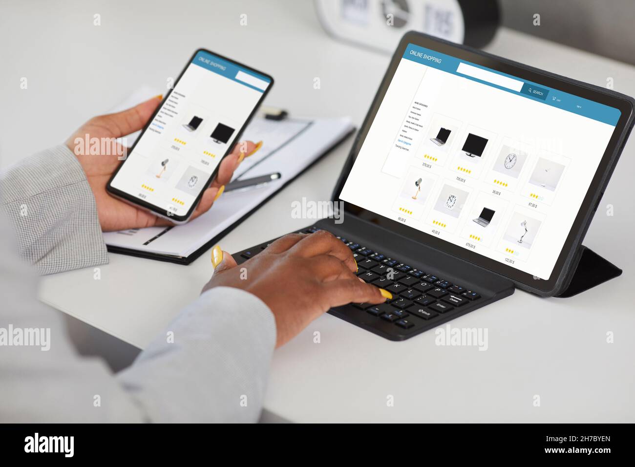 Frau, die online einkaufen, auf der Website des Internetstore auf dem Tablet surfen und die App auf dem Mobiltelefon verwenden Stockfoto