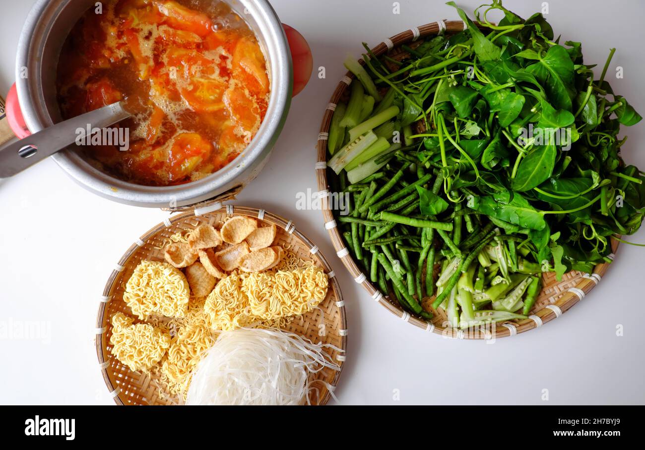 Draufsicht Vietnamesisch veganes Essen, grünes Gemüse Hotpot aus Tomaten, Sojaprotein, Chilisatte, Amaranth, Pfefferlunder, Brötchen, Spinat, gesund Stockfoto