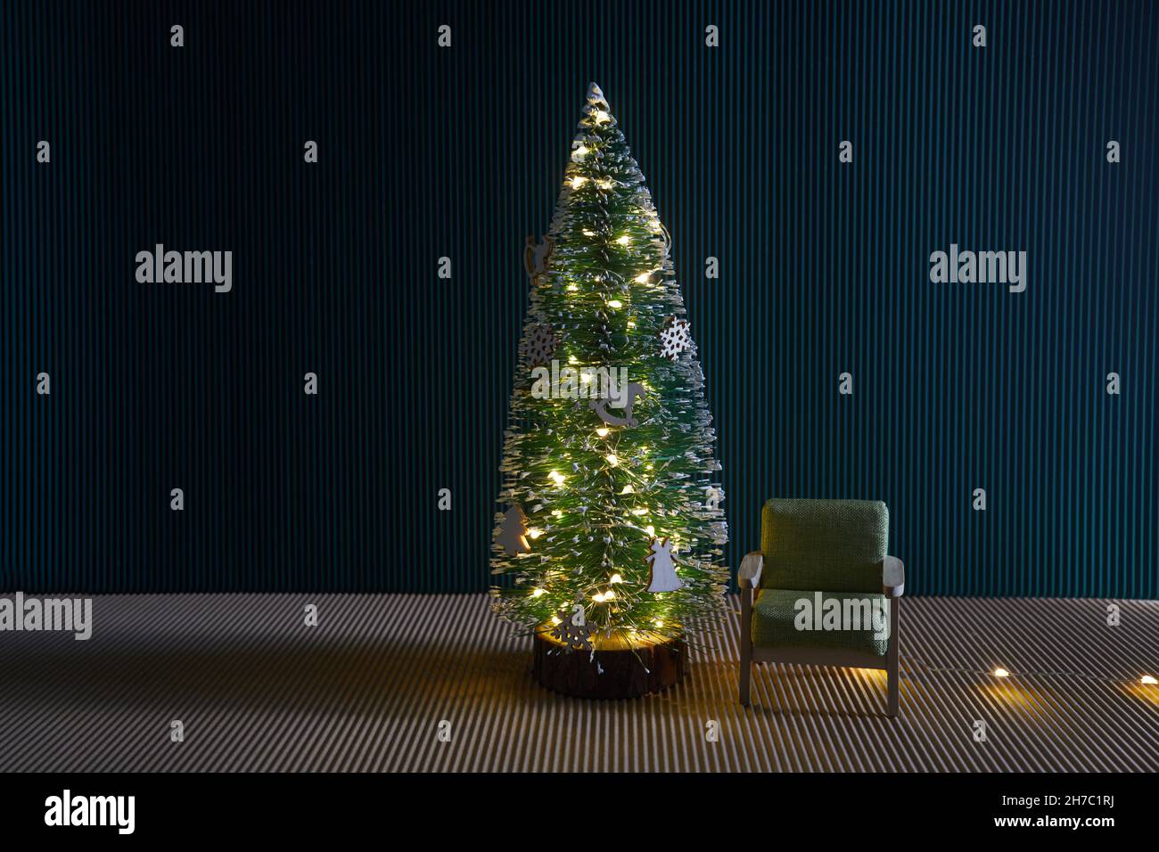 Weihnachtskonzept Innenraum, weihnachtsbaum, Stuhl, in leerem Raum Innenraum mit grüner Wand. Stockfoto