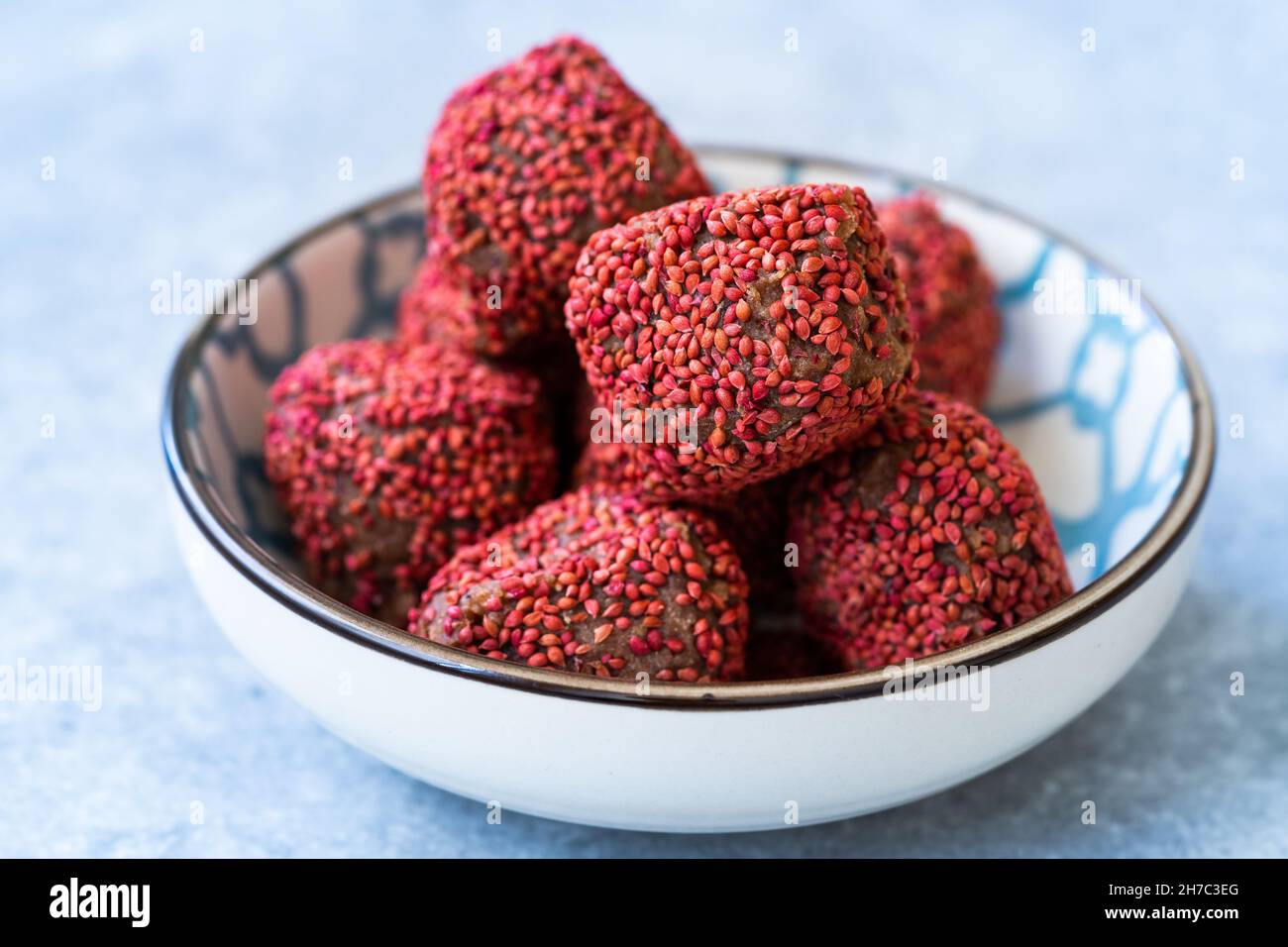 Rote getrocknete Dattel-Fruchtbälle mit Waldfrüchten. Paleo Raw Energy Balls. Bereit zum Essen. Stockfoto