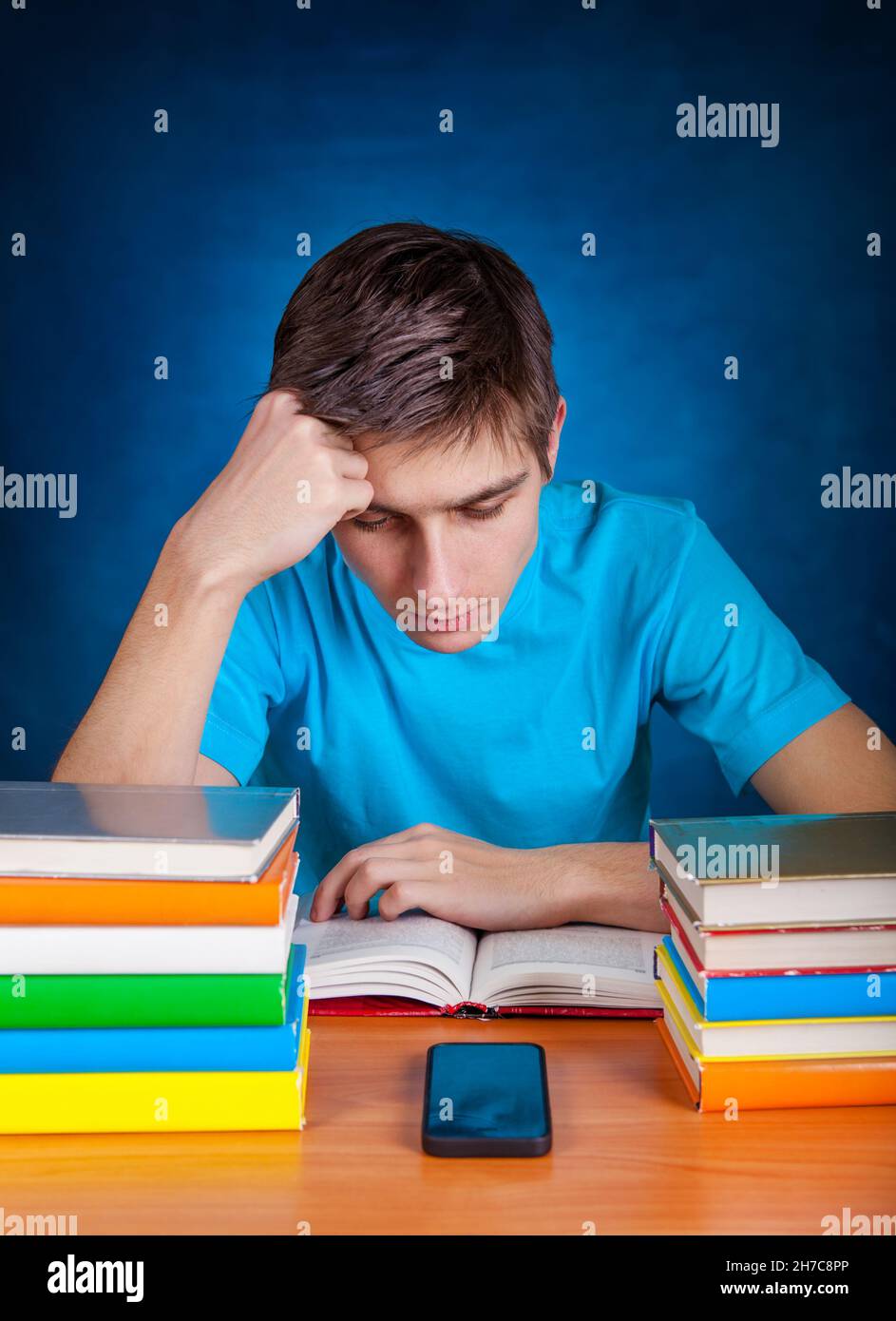 Seriöse Schülerin las das Buch am Schulschalter Stockfoto