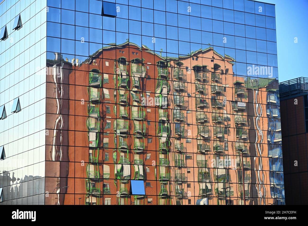 Szenische Aufnahme einer verzerrten Spiegelung von Wohngebäuden in der Spiegelfassade Stockfoto